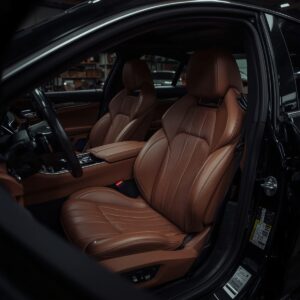 interior de carro de luxo com bancos de couro marrom após higienização automotiva completa